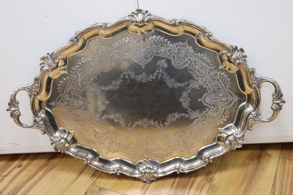 A large shaped oval silver two-handled tray with shell and scroll border, approx 116oz